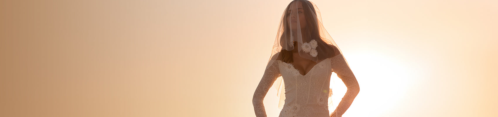 Model in our Gigi wedding dress with the sunset behind her