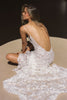 woman wearing a white lace backless dress with thin straps and delicate chain jewellery across her back_XS_
