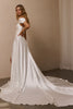 A woman modeling a white satin wedding gown with a short puff sleeve, a low back cutout, and a long train in a softly lit indoor setting_XS_