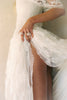 A woman wearing a white off-the-shoulder lace wedding gown with a deep V neckline and a full layered skirt_XS_