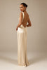 A woman modeling a floor-length cream satin gown from the back, showing a deep open back and draped neckline, set against a solid warm beige studio background_XS_