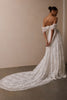 A woman wearing a white off-the-shoulder lace wedding gown with a deep V neckline and a full layered skirt_XS_