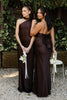 Two women in brown bridesmaid dresses in an outdoor garden