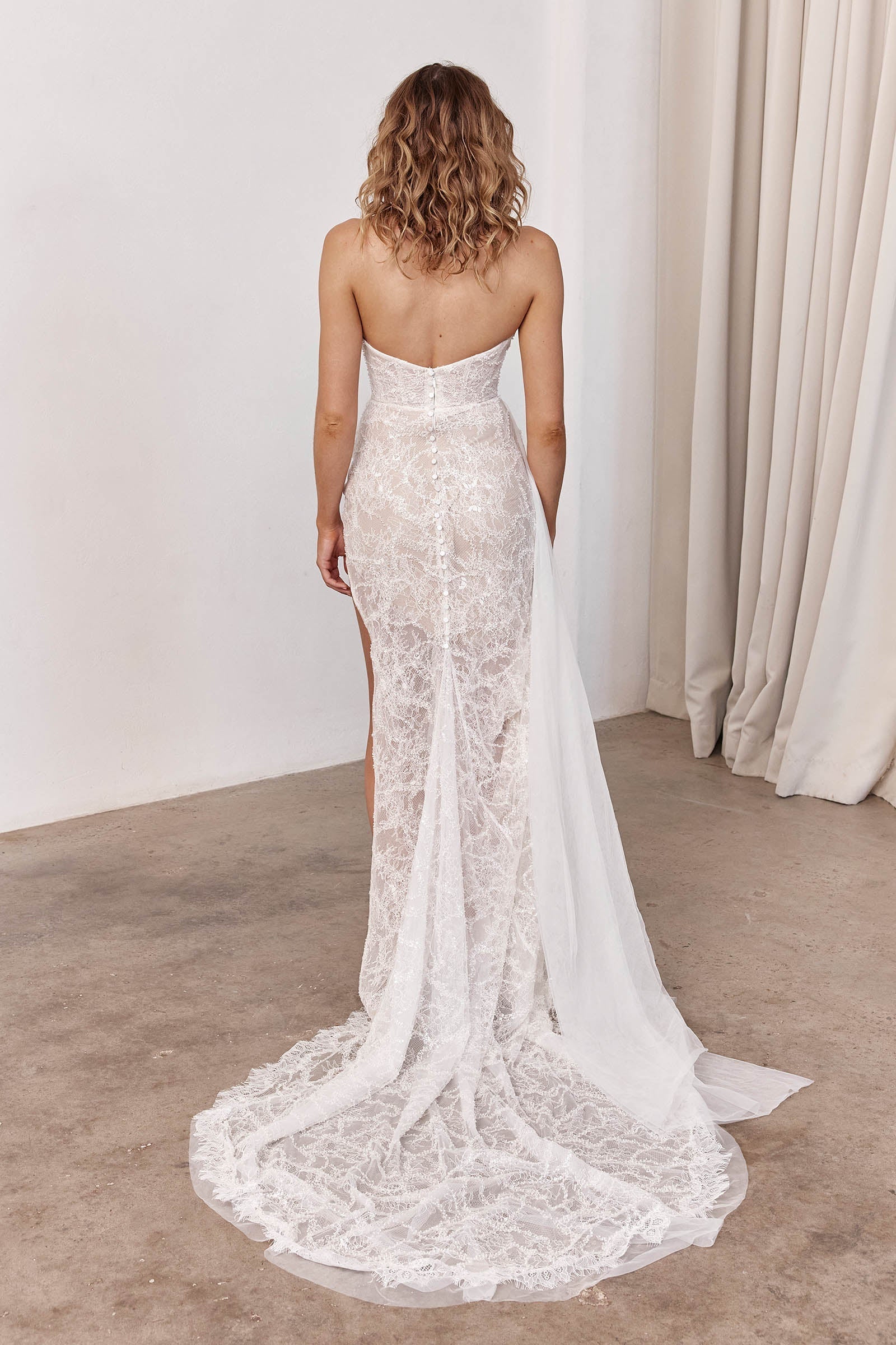 Woman wearing a lace wedding dress with a long train_XS_