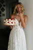 Woman in a strapless wedding dress holding a cake_XS_