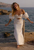 Woman in a satin wedding dress standing by the sea_XS_