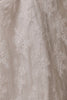 Close-up of a sheer champagne lace fabric with intricate floral embroidery and tulle texture.