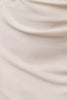 A close-up of draped cream-colored fabric with soft folds and a smooth texture.
