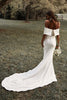 Woman in a garden wearing an off-the-shoulder crepe wedding dress