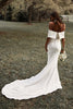 Woman in a garden wearing an off-the-shoulder crepe wedding dress