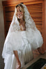 Woman wearing a satin wedding dress and lace mantilla veil_XS_