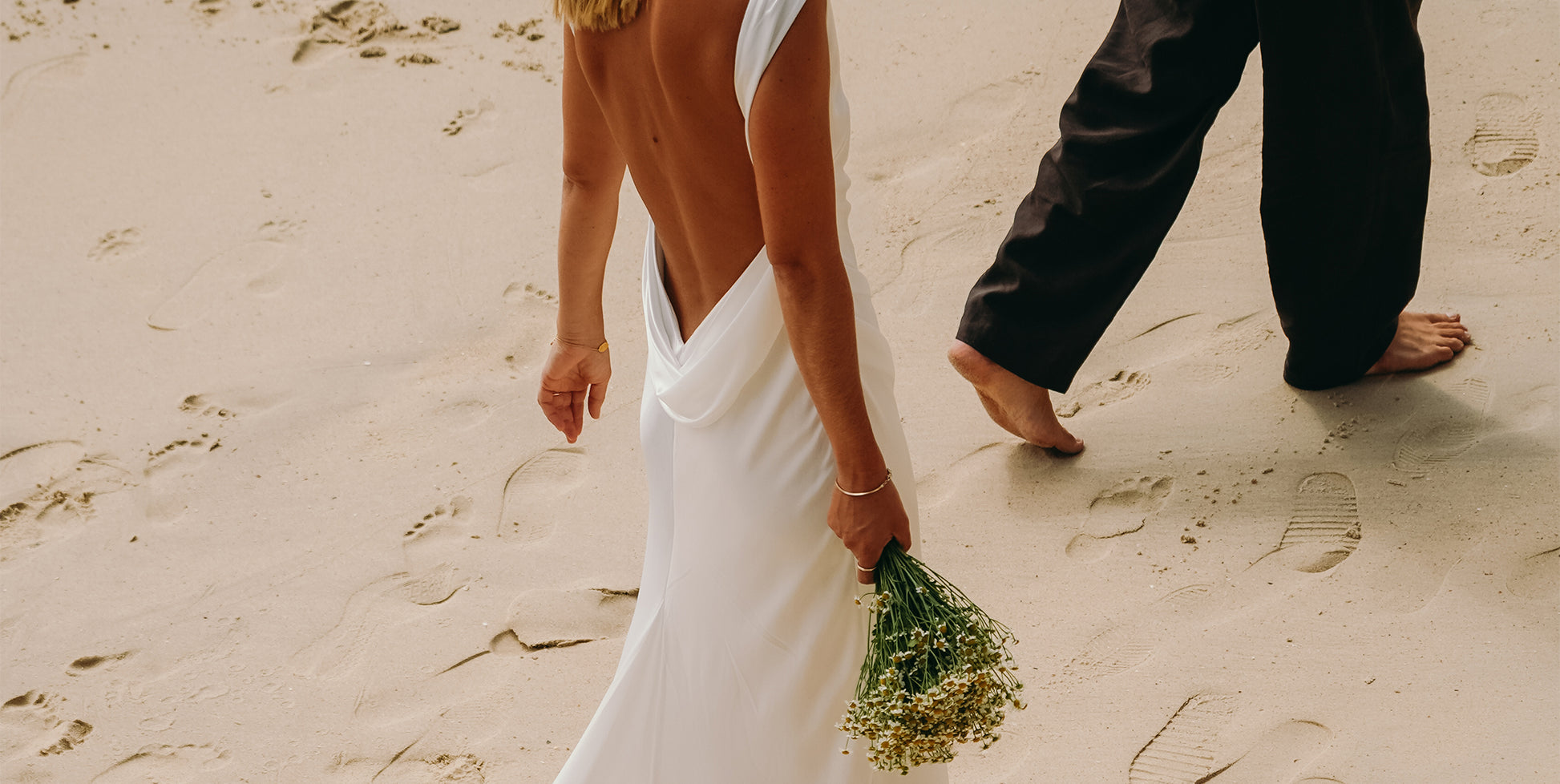 Bride and groom walking along the beach.