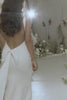 A woman wearing a low back crepe wedding dress.