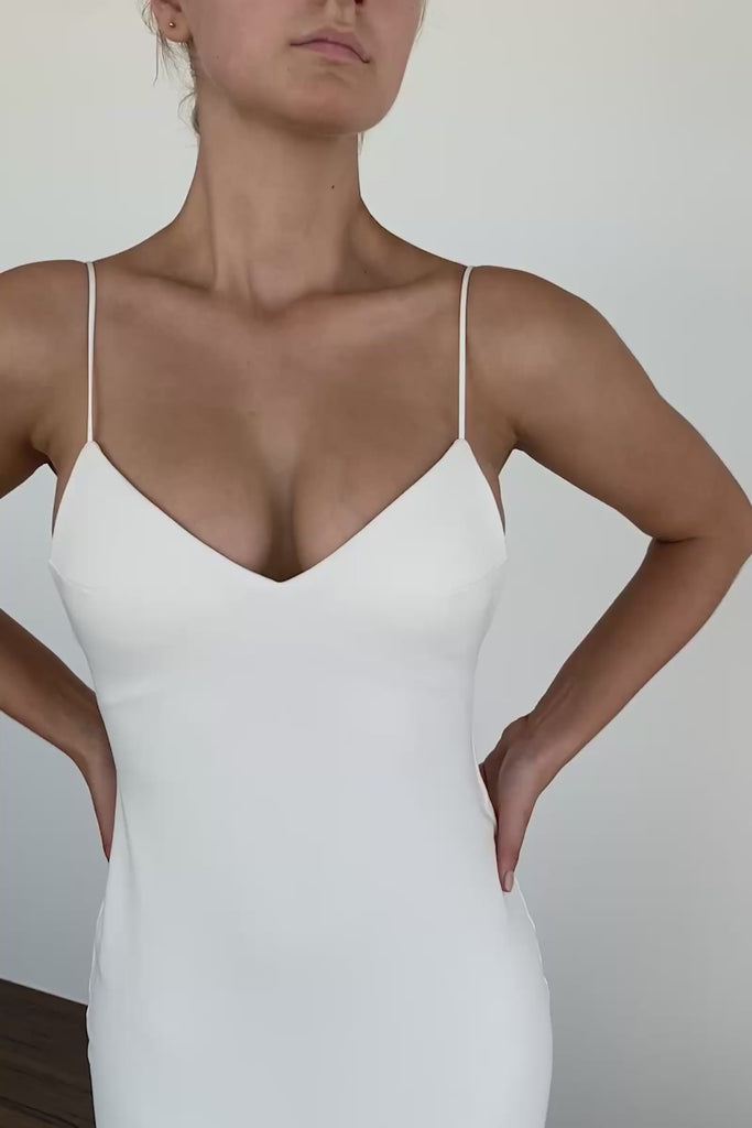 Woman wearing a spaghetti strap crepe wedding dress.