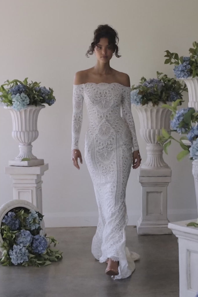 A woman in a lace off the shoulder wedding dress.